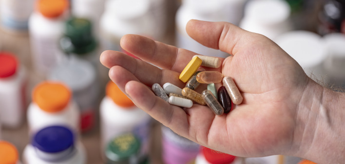 hand holding vitamins and supplements