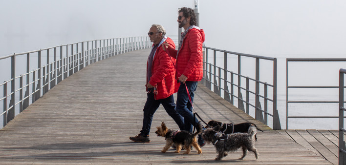 Portugal man living with HIV with a taller man walking on a pier