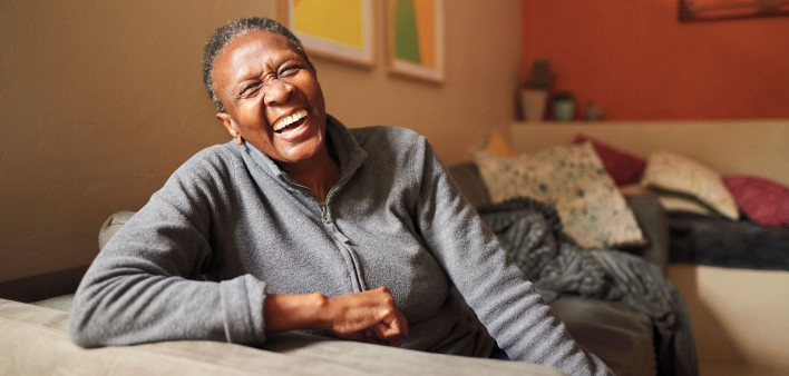 African American Black woman laughing on couch