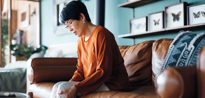 sad asian woman sitting on a couch