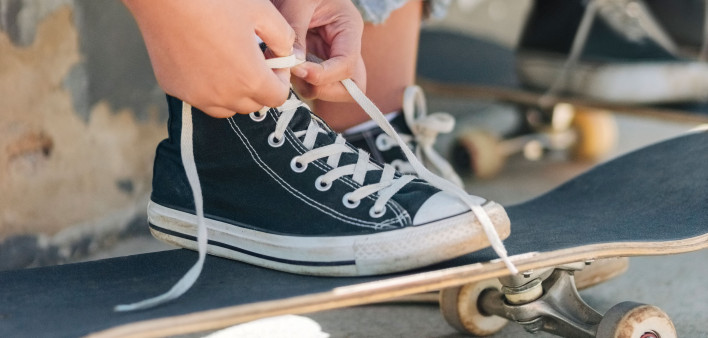 young persons hands tying their shoes