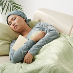 Asian woman with cancer sleeping on couch