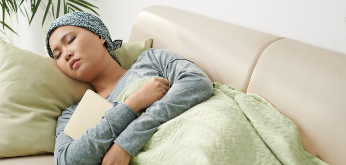 Asian woman with cancer sleeping on couch
