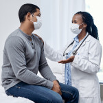 black doctor taklking to latin patient