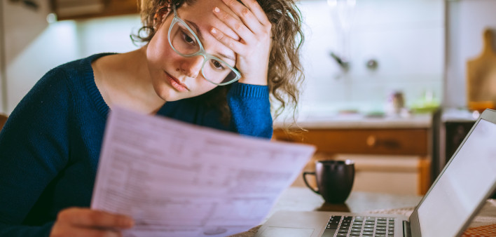 Woman going through bills, looking worried