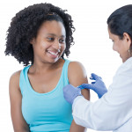 girl receiving vaccine from female doctor