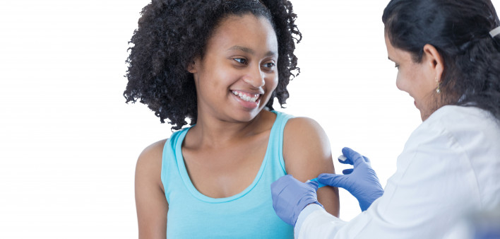 girl receiving vaccine from female doctor