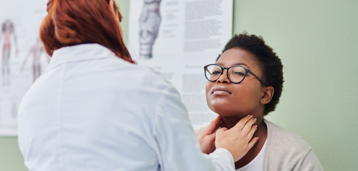 black woman getting thyroid exam