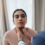 doctor checking patients throid gland