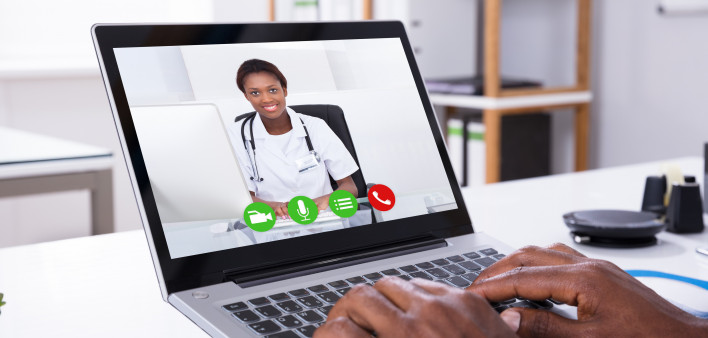 Close-up Of A Person Video Conferencing With Female Doctor Through Laptop