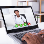 Close-up Of A Person Video Conferencing With Female Doctor Through Laptop