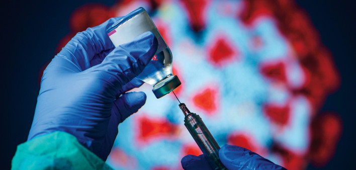 gloved hand needle vial vaccine coronavirus