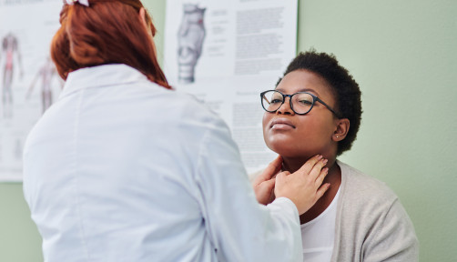 black woman getting thyroid exam
