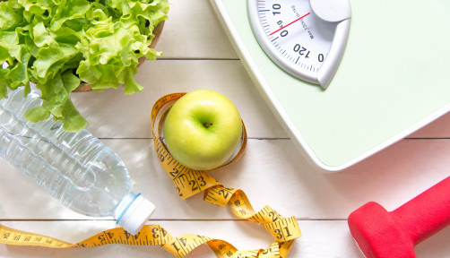 Green apple and Weight scale,measure tape with fresh vegetable, clean water and sport equipment for women diet slimming