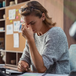 Exhausted businesswoman having a headache in modern office.