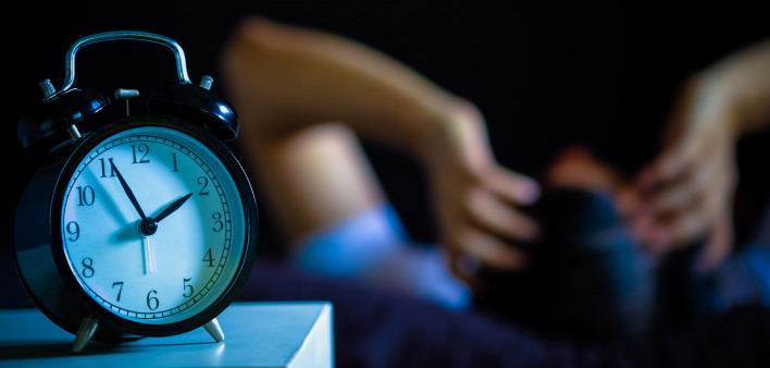 Asian man in bed suffering insomnia and sleep disorder thinking about his problem at night