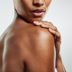 Studio shot of an attractive young woman posing against a grey background