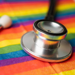 Black stethoscope on rainbow flag background,