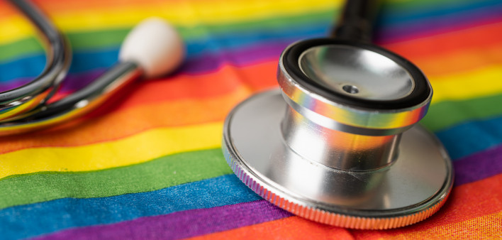 Black stethoscope on rainbow flag background,