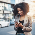 Shot of a young businesswoman using a cellphone in the city
