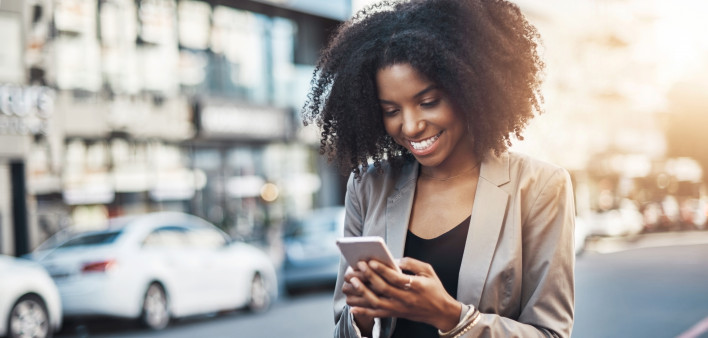 Shot of a young businesswoman using a cellphone in the city