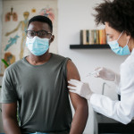 black patient man getting vaccine face mask covid coronavirus