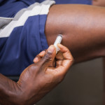 Close up of muscular man injecting steroids in the gym testosterone