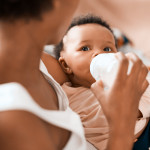 Shot of a mother feeding her adorable infant daughter at home