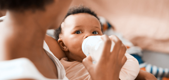 Shot of a mother feeding her adorable infant daughter at home