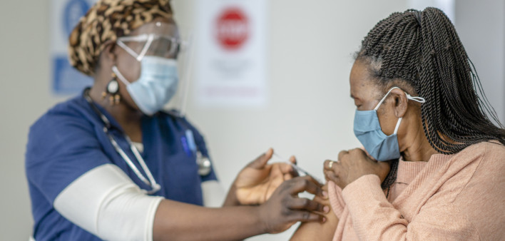 A senior female is receiving her COVID-19 vaccine