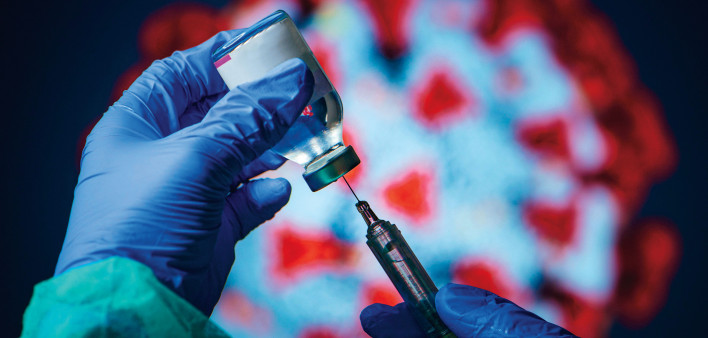 gloved hand needle vial vaccine coronavirus