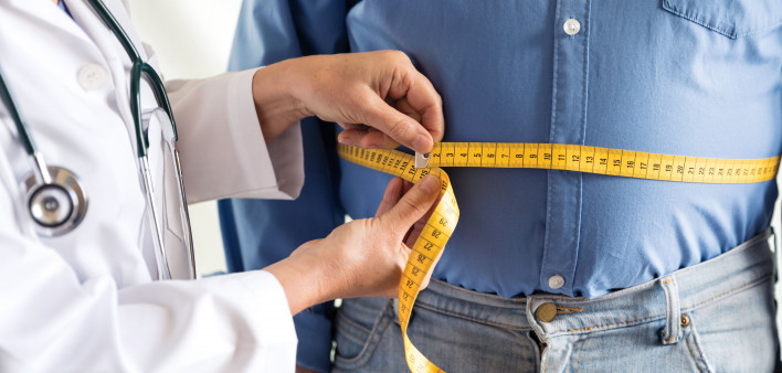 doctor measuring mans stomach