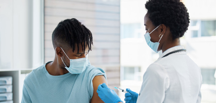 Young man being given an injection vaccine