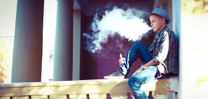 well dressed teen vaping e cigarette