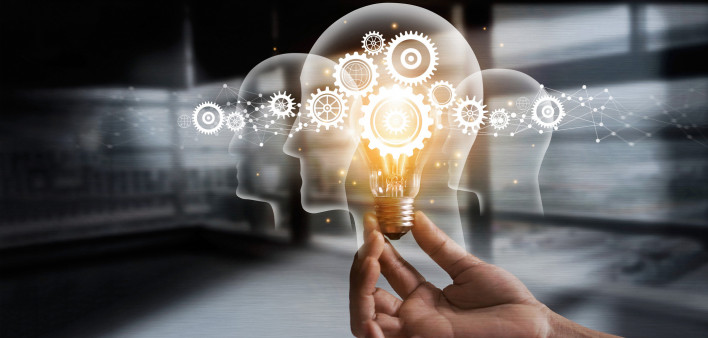 illustration of hand holding light bulb over head shapes and cogs