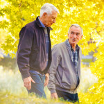 Senior gay couple enjoying a walk sunny Autumn day