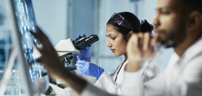 Scientist Working on Computer In Modern Laboratory all graps, dna models,