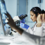 Scientist Working on Computer In Modern Laboratory all graps, dna models,