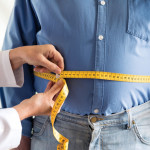 doctor measuring mans stomach