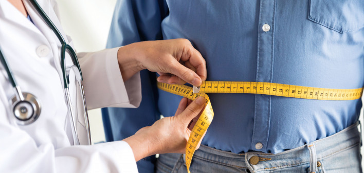 doctor measuring mans stomach