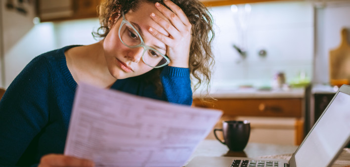 Woman going through bills, looking worried
