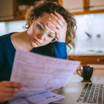 Woman going through bills, looking worried