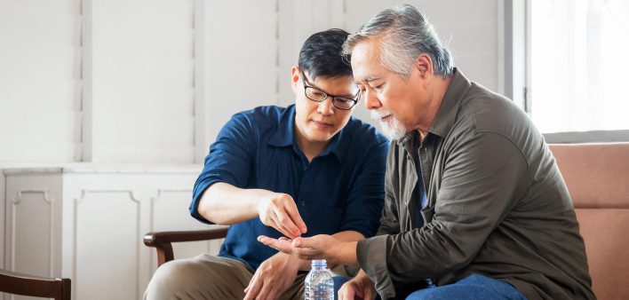 young asian man old asian man getting pills medication