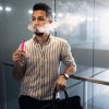 Young latino man e-cigarette smoking