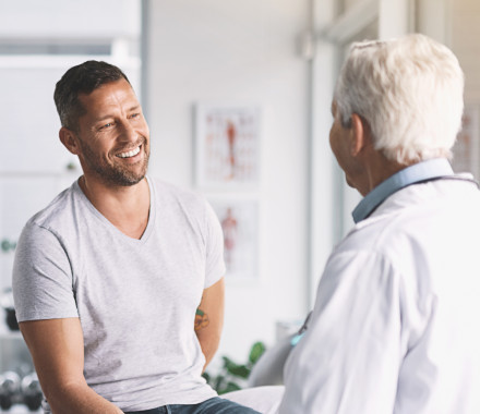 senior doctor giving his male patient a thorough checkup during his consultation