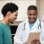 Doctor and patient looking at digital tablet in exam