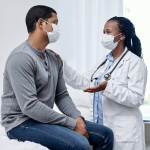 black doctor taklking to latin patient