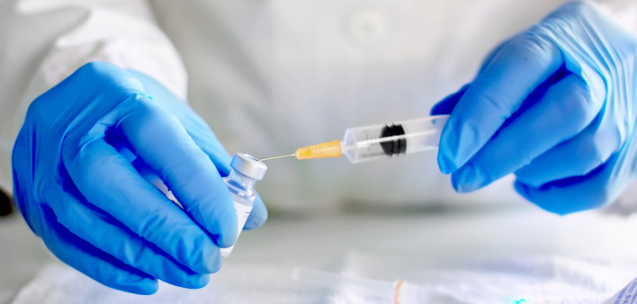 Doctor fills injection syringe with vaccine