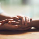 Shot of two people holding hands in comfort