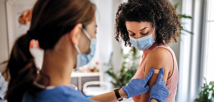 Nurse giving vaccine to patient